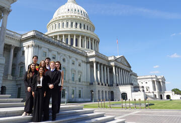 Several students pose on the steps of the U.S. Capitol following the final site visit of Honors College.