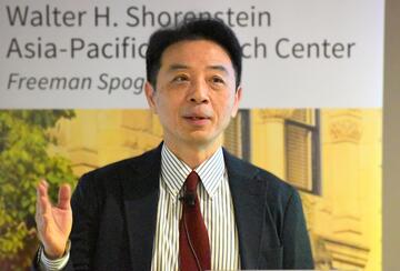 Weitseng Chen presents at a lectern.