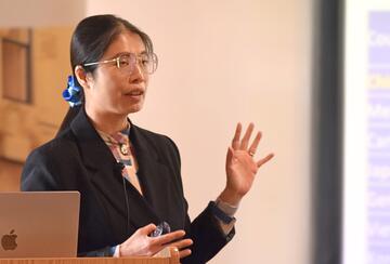 Hsiao-Hui Lee presents at a lectern.