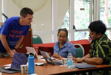three teachers working on an activity around a table