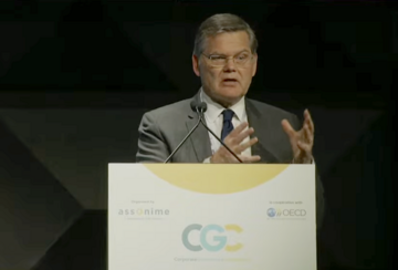 Curtis Milhaupt delivers a speech at a podium.