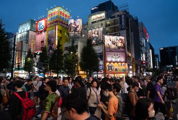 People cross a road in the Akihabara district in Tokyo, Japan.
