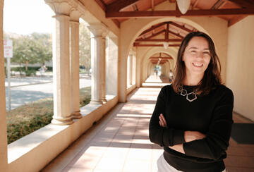 Stanford's Maria Polyakova stands amid the university's sandstone columns.