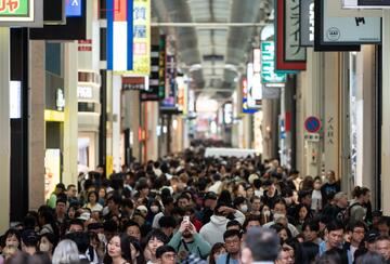 People walk through a shopping street in Osaka, Japan, 2024.
