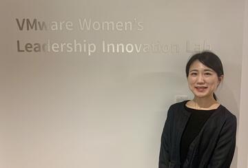 a student posing in front of a sign