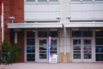 Building with glass doors and polling station signage out front