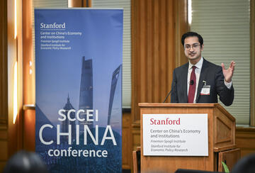 Rush Doshi speaks behind a podium at the SCCEI China Conference