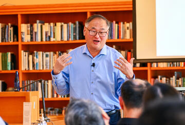 Chang-Tai Hsieh speaks during a lecture in a library. 