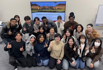 group of students posing in front of a screen