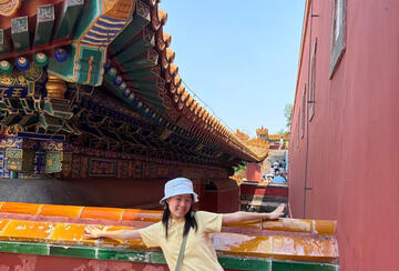a student standing in front of a building