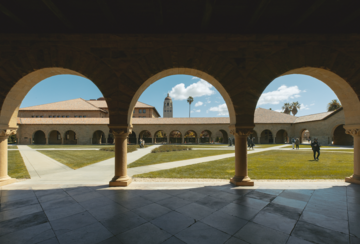 A view of the Stanford memorial quad with arches in the forefront. 