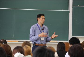 a person giving a talk in front of a class