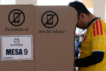 A man in a Colombian football jersey casts his vote in the presidential election on May 31, 2026, in Bogotá, Colombia.