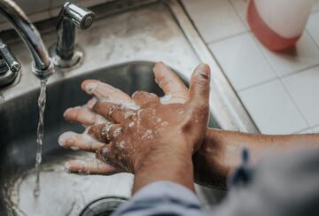 Person in blue shirt washing hands