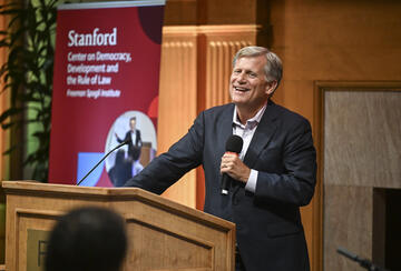Michael McFaul speaks into a microphone at a podium
