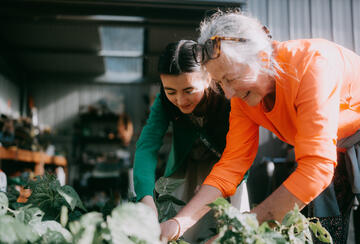 A grandmother gardens with her granddaughter