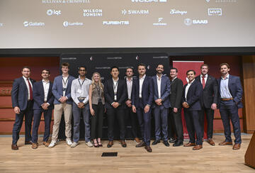 Student organizers pose together on stage at the 4th Annual Stanford Conference on Technology and National Security