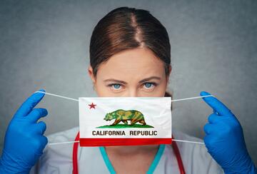 Women doctor holds a surgical mask with the California Republic flag.