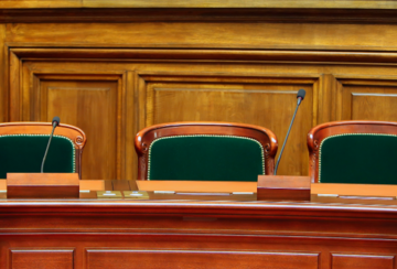 image of seats in court with a microphone at one seat