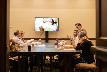 Group of people deliberating around a table