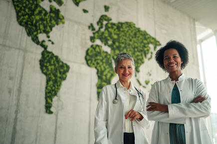 Two women doctors in front of world map
