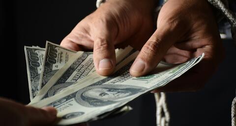 Person holding $100 US bills