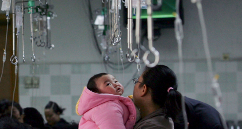 A parent holds a child waiting to be given an infusion at an area hospital in China.