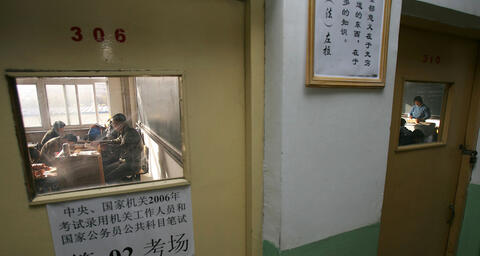 A group of people behind a closed door taking the national civil servant qualification exam in Beijing.