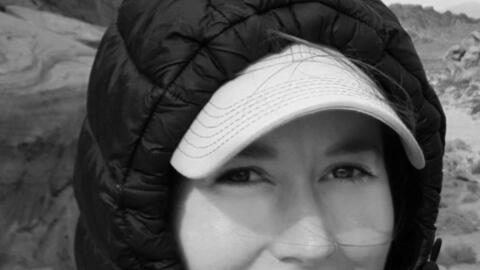 Headshot of Emilia Groupp. Groupp has a hood up and a baseball cap on.