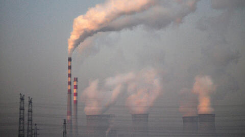 Smoke stacks in China releasing smoke into a polluted sky.