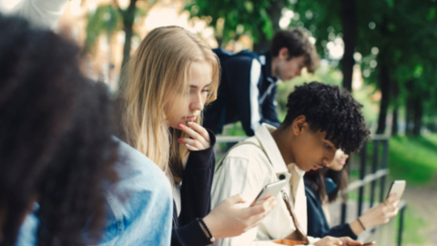 group of teens looking at phones