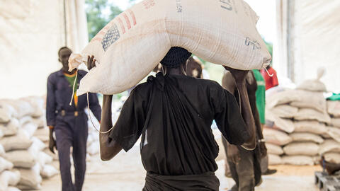 Man carries USAID sack of grain 