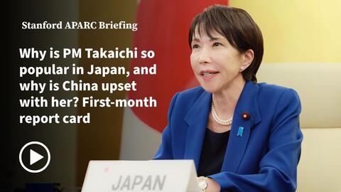 Japan's Primse Minister Sanae Takaicichi seated on the backdrop of the Japan flag.