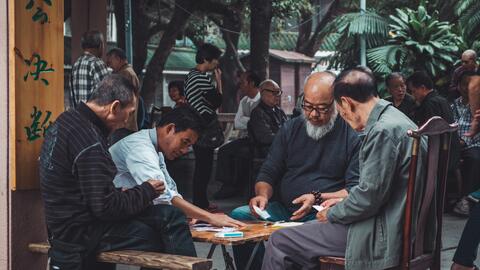 Elderly citizens play a game together in a oublic square in China,