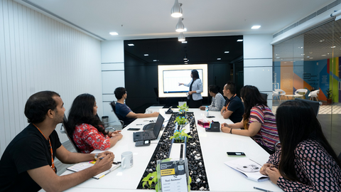 Office workers watch a presentation in an office conference room.