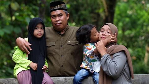 An Indonesian family of four posing to the camera.