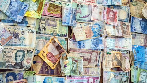 A wall displaying many kinds of Latin American paper currencies