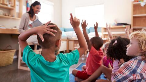 Photo of a teacher and kids in preschool classroom