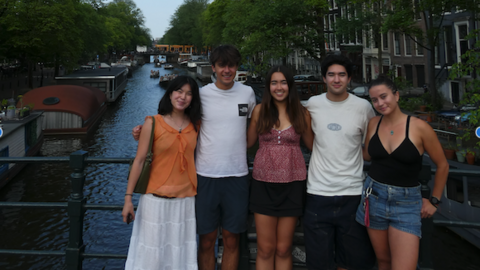 Group photo of five interns in front of a canal in Amsterdam