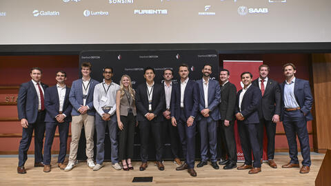 Student organizers pose together on stage at the 4th Annual Stanford Conference on Technology and National Security