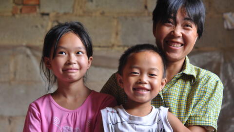 Portrait of a happy mother, young son, and daughter in rural China.
