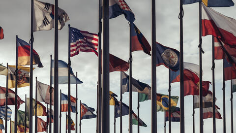Flags of many countries at the tops of their poles