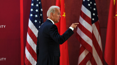 President Biden walks past a row of Chinese and American flags.