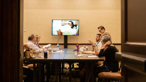 Group of people deliberating around a table