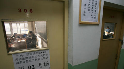 A group of people behind a closed door taking the national civil servant qualification exam in Beijing.