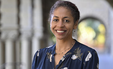 An African American woman wearing a floral blouse and smiling. 