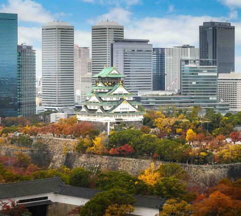 Osaka Castle and garden with city skyline at autumn season in Osaka, Japan.