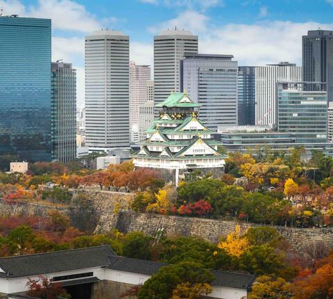 Osaka Castle and garden with city skyline at autumn season in Osaka, Japan.