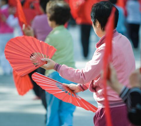 women dancing with red fans