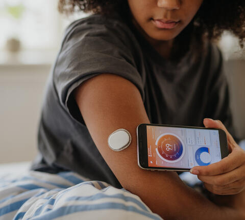 A teenage girl checking her glucose using phone app